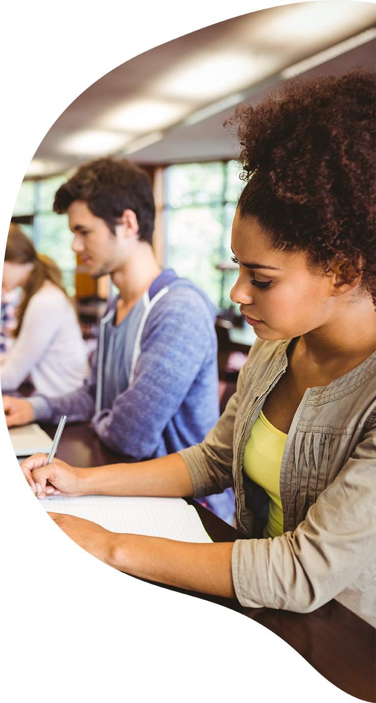 College students intently working with pen and paper on a desk