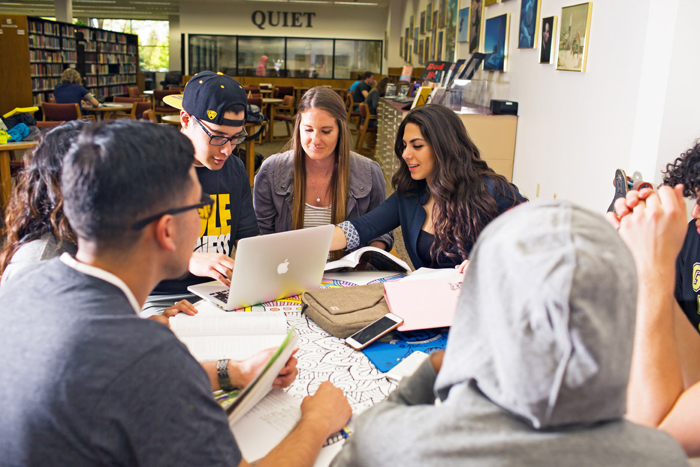 CSI students gather in the CSI library gathered around a laptop